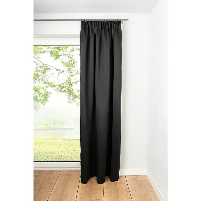 Schlaufenschal Day & Night - B x H: 135 x 300 cm, 100 % Polyester, Schwarz - Blick auf einen schwarzen Vorhang, der vor einem Fenster hängt und einen Raum abdunkelt. Holzfußboden im Vordergrund.