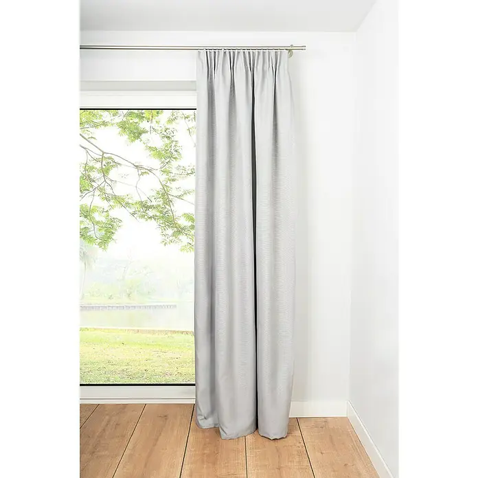Verdunkelungsvorhang Dim - B x H: 135 x 300 cm, 100 % Polyester, Grau - Grauer Vorhang hängt elegant an einer Stange vor einem Fenster und verleiht dem Raum eine stilvolle Atmosphäre.