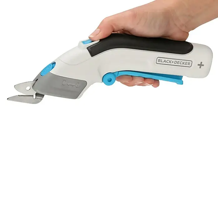 Black+Decker Tijera de batería BCSC115 3,6V-Li - 3,6 V, 1 batería, 1,5 Ah - Una mano sostiene unas tijeras eléctricas para tela Black+Decker con un acento azul sobre un fondo negro.