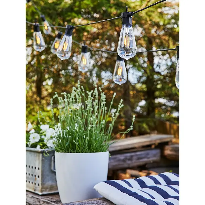 Garden 24 LED-Lichterkette - Außen, 550 mm, Lichtfarbe: Warmweiß, Oval - Lichterketten im Außenbereich sorgen für eine gemütliche Atmosphäre, während Pflanzen und Kissen die Szene vervollständigen.