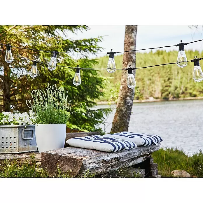 Garden 24 LED-Lichterkette - Außen, 550 mm, Lichtfarbe: Warmweiß, Oval - Outdoor-Lichterkette mit schwarzem Kabel und klaren Edison-Glühbirnen, hängt in einem Garten am See.