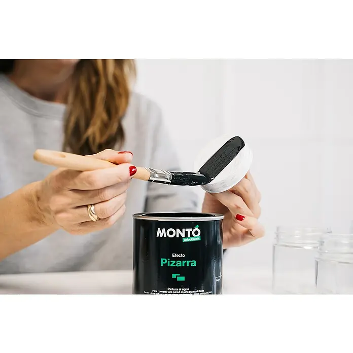 Pintura para efectos decorativos Pizarra - Negro, 500 ml - Se está utilizando una lata de pintura de pizarra Montó para pintar un objeto pequeño con un pincel.