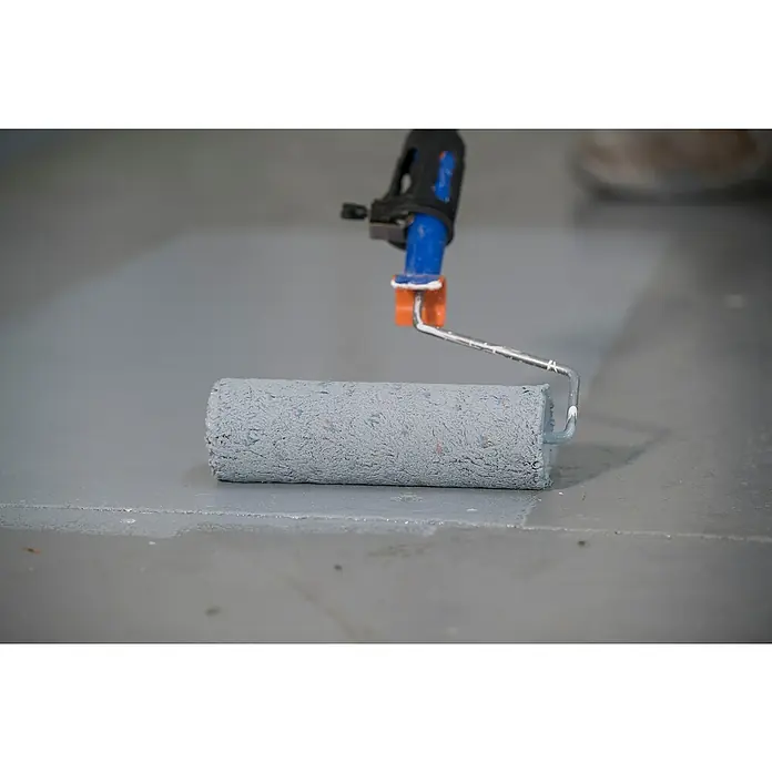Montó Pintura para suelos Expresa - Gris, 4 l, Mate sedoso - Primer plano de un rodillo de pintura con mango sobre una superficie gris, ideal para pintar paredes o suelos.