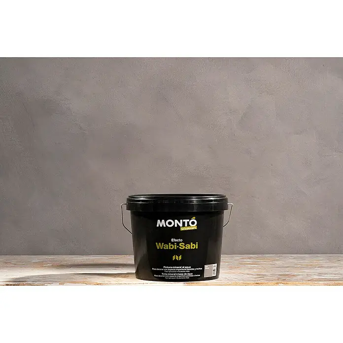 Montó Bricolovers Yeso con efecto de color Wabi Sabi - Gris intenso, Mate - Cubo negro de pintura de efecto Montó Wabi-Sabi sobre una superficie clara frente a una pared gris para un aspecto natural y elegante.
