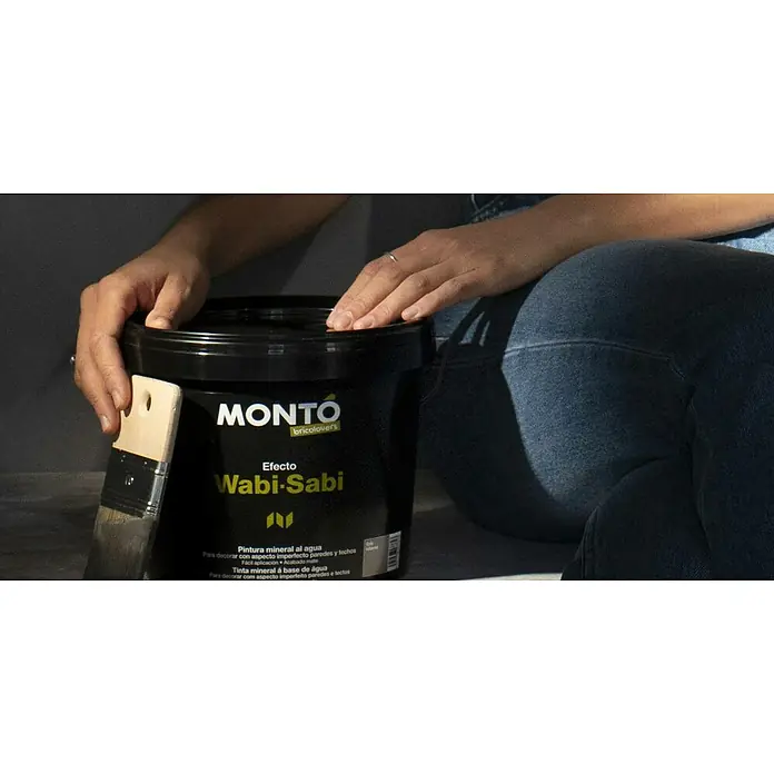 Montó Bricolovers Yeso con efecto de color Wabi Sabi - Gris intenso, Mate - Primer plano de un bote de pintura "MONTO bricolovers" con efecto Wabi-Sabi y un pincel, ideal para decorar paredes y techos.