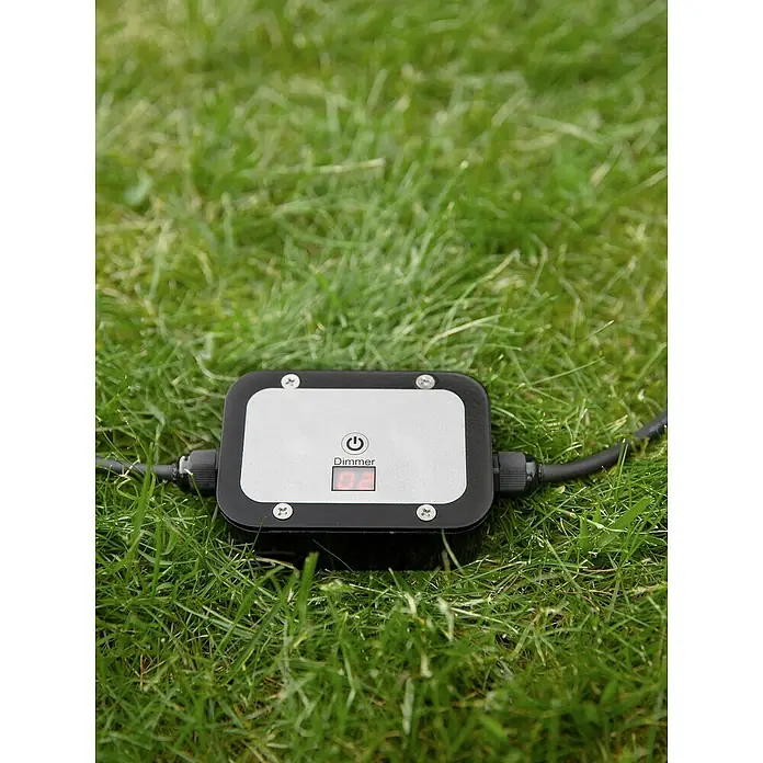 Garden 24 Bewegungsmelder Dimmer - Schwarz, L x B x H: 10 x 10 x 3,5 cm - Nahaufnahme eines Dimmer-Geräts mit digitaler Anzeige auf einer grünen Grasfläche.