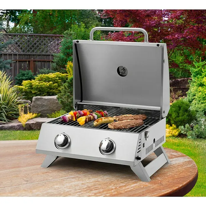 Tepro Gasgrill Chicago - Grillfläche (B x T): 47 x 36 cm, 6 kW, Anzahl Brenner: 2 - Edelstahl Grill mit Grillgut. Der tragbare Gasgrill mit zwei Brennern bietet hohe Leistung für Picknicks, Camping und mehr.