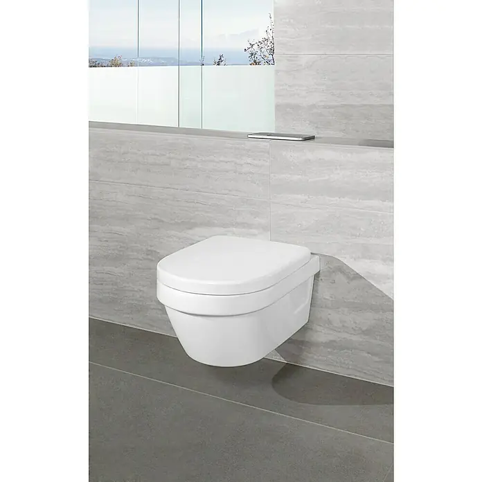 Villeroy & Boch Architectura Wand-WC-Set Compact - Spülrandlos, Mit schmutzabweisender Glasur, Spülform: Tief, WC Abgang: Waagerecht, Weiß - Nahaufnahme einer modernen, wandhängenden Toilette in einem Badezimmer mit grauem Fliesendesign und einem Smartphone auf der Ablage.
