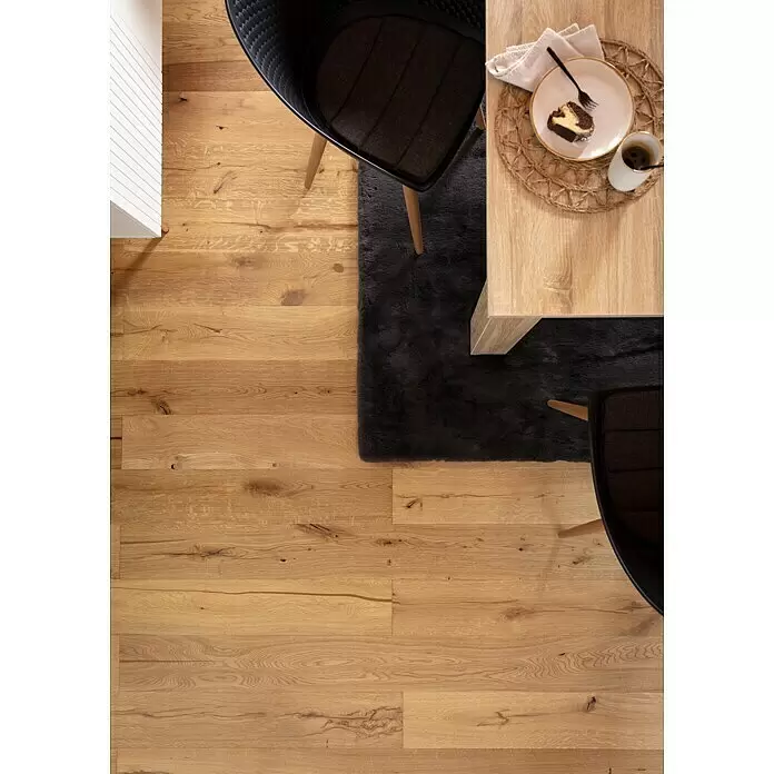 Parkett - Eiche Rügen, Landhausdiele, 2.130 x 190 x 14,2 mm - Heller Holzfußboden in einem Essbereich mit dunklem Teppich, Tisch und Stühlen. Natürliche Maserung sichtbar.