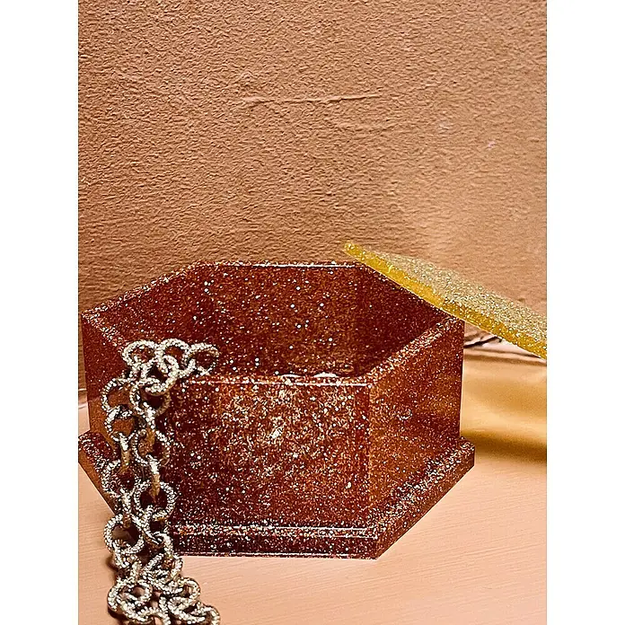 Fleur Molde Joyero - Silicona - Brillante joyero hexagonal de bronce dorado con tapa adyacente y cadena plateada.