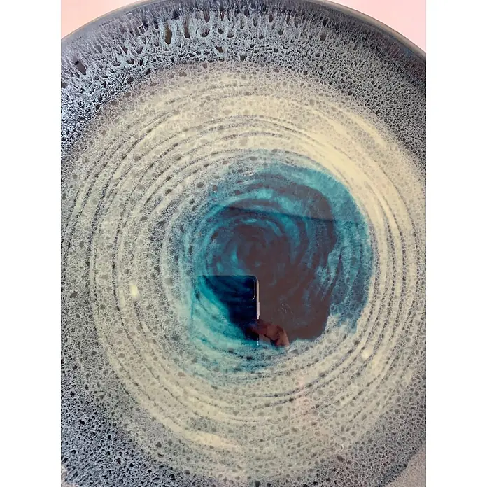 Fleur Pigmento concentrado Polvo metálico - Azul, 5 g - Un primer plano de un cuenco de cerámica artístico con patrones de color azul y blanco, que recuerda un ojo abstracto o un remolino.