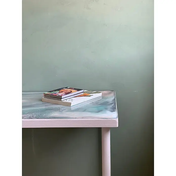 Fleur Colorante líquido para resina - Marrón chocolate, 10 ml - Primer plano de una mesa con dos libros encima, con una pared verde de fondo.