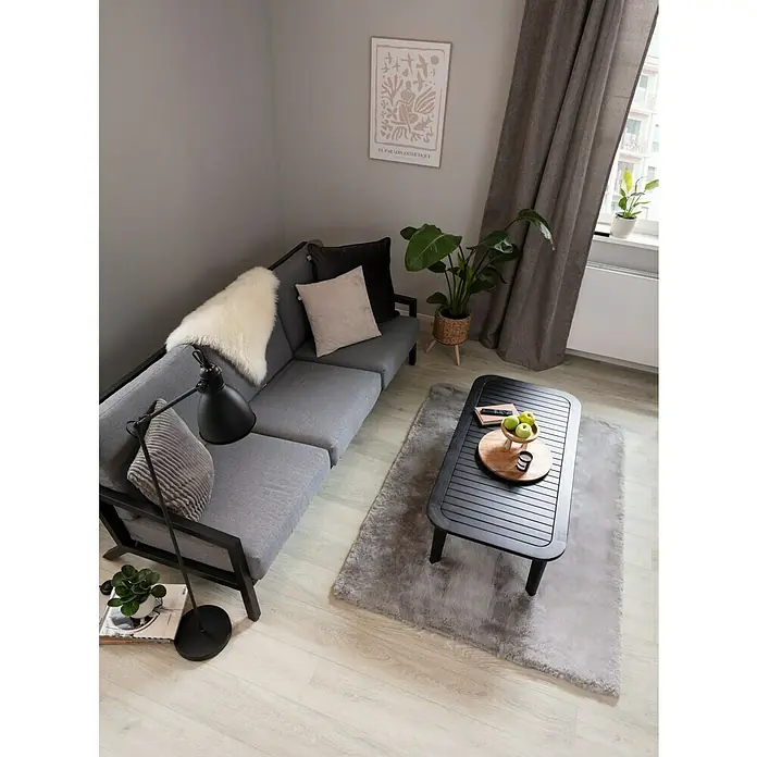 Fellteppich Happy - Silber, 330 x 240 cm, 100 % Polyester (Flor) - Ein gemütliches Wohnzimmer mit einem grauen Sofa, einem Couchtisch und einer Zimmerpflanze, die für eine entspannte Atmosphäre sorgen.