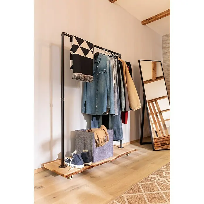 Exclusivholz Blockware - Douglasie, Anfallende Breite: 20 cm - 25 cm, 120 x 3 cm - Eine Nahaufnahme eines Kleiderständers mit Kleidung, Schuhen und einem Spiegel. Der Ständer hat eine Holzbasis und ein modernes Design.