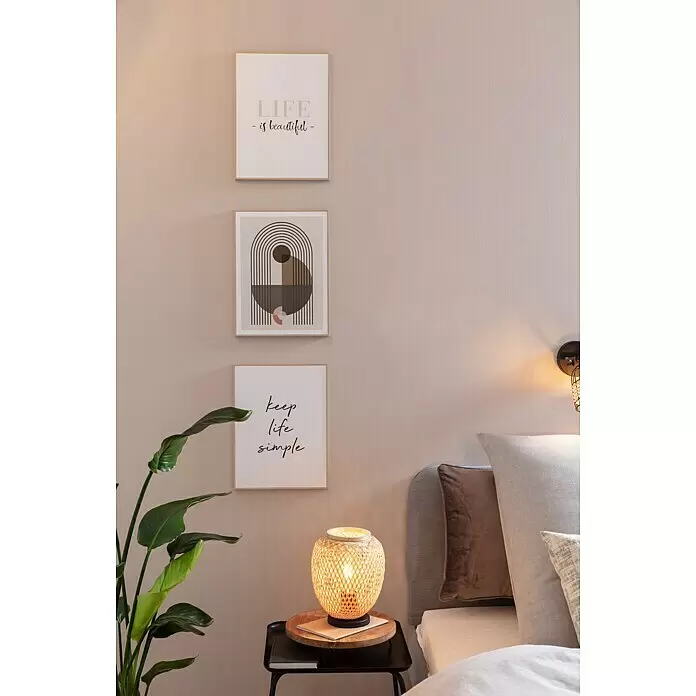 Eglo Dembleby Tischleuchte - 40 W, Natur, E27 - Dreiteiliges Set gerahmter Wandbilder mit inspirierenden Zitaten und abstrakter Kunst, an einer Schlafzimmerwand über einer geflochtenen Nachttischlampe.