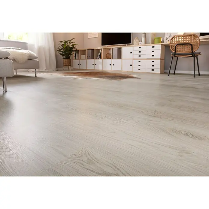 Corklife Freestyle Korkboden - Oak Taupe, Landhausdiele, 1.220 x 185 x 8,5 mm - Nahaufnahme eines hellen Holzlaminatbodens mit natürlicher Maserung in einem modernen Wohnzimmer. Möbel und Deko im Hintergrund verschwimmen.