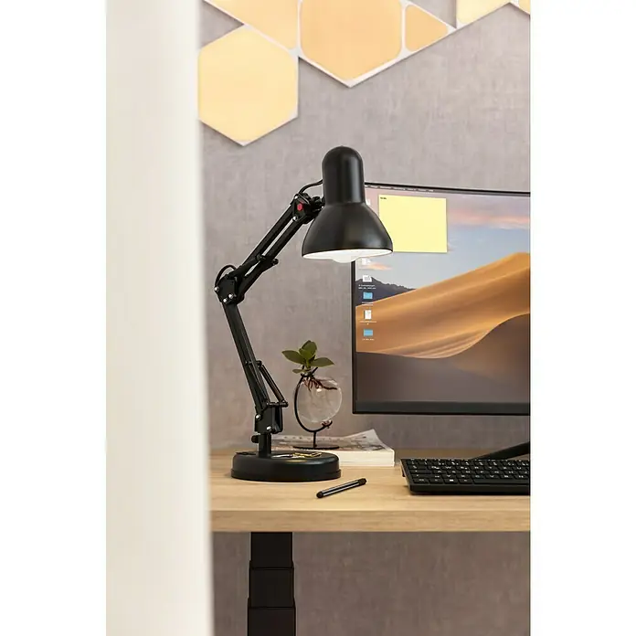 Globo Lámpara de sobremesa Famous - 40 W, Negro, Negro, E27 - Lámpara de escritorio negra con brazo ajustable sobre un escritorio de madera clara con decoración minimalista al fondo.