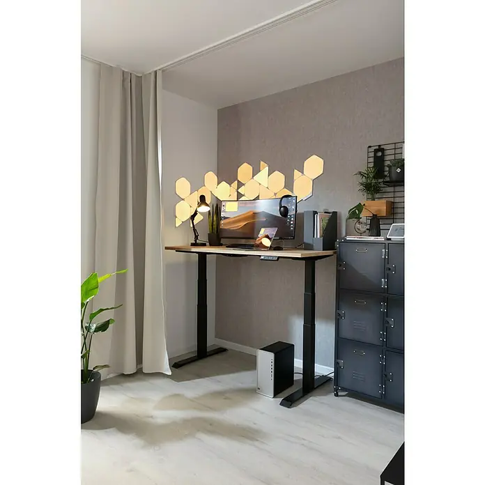 Rasch LOFT Vliestapete Uni - Grau, Betonoptik, 10,05 x 0,53 m - Ein moderner Arbeitsplatz mit einem höhenverstellbaren Schreibtisch und hexagonförmigen Wandleuchten, der ein stilvolles und funktionales Ambiente schafft.