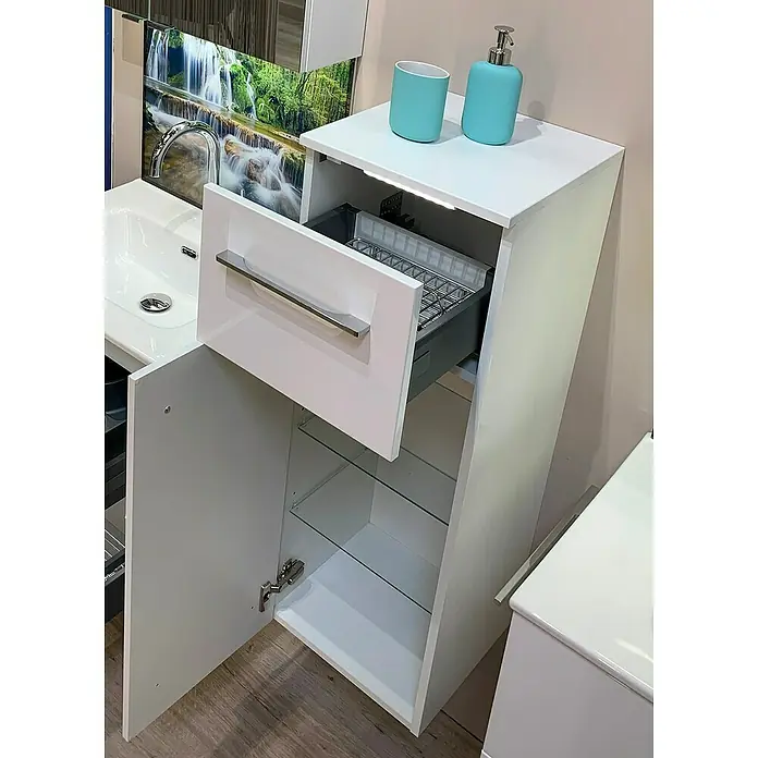 Astor Hängeschrank Cool Clean mit UVC-Desinfizierungsmodul - 37 x 35 x 101 cm - Badezimmerschrank mit offenem Schublade und Tür, ausgestattet mit Glasböden und zwei blauen Accessoires auf der Oberseite.