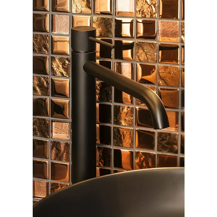 Mosaikfliese Quadrat Crystal XCM 32BR1 - 30 x 30 cm, Bronze, Glänzend - Ein moderner, mattschwarzer Wasserhahn vor einem schimmernden Mosaikhintergrund, der das elegante Design und die hochwertige Verarbeitung hervorhebt.