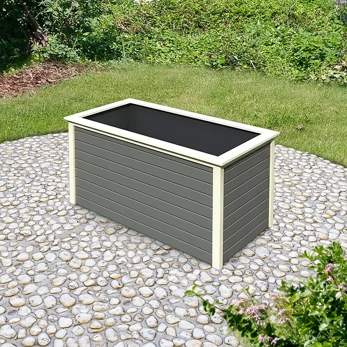 Karibu Hochbeet 2 - 173 x 89 x 82 cm, Holz, Grau - Nahaufnahme eines stilvollen grauen Pflanzkastens mit cremefarbenen Akzenten, der auf einem Kieselhaufen im Freien steht.