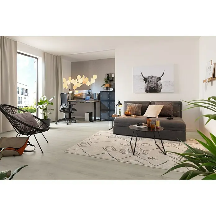 Rasch LOFT Vliestapete Uni - Grau, Betonoptik, 10,05 x 0,53 m - Einrichtung eines Wohnzimmers mit Sofa, Tisch, Teppich, Stuhl und Schreibtisch mit Beleuchtung, die eine gemütliche und moderne Atmosphäre schafft.