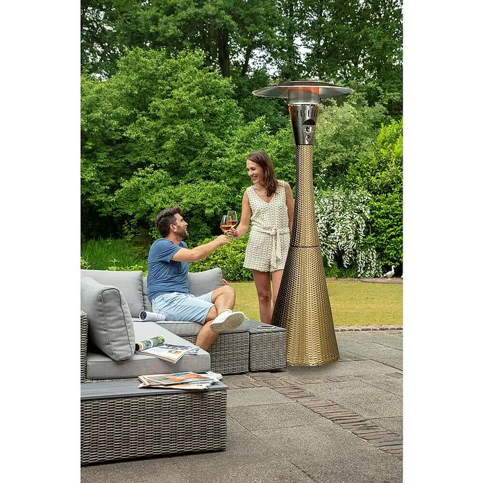 Estufa de exterior Lund - 12 kW, Altura: 225 cm - Una mujer y un hombre brindan con copas de vino mientras un elegante calefactor de patio en el fondo agrega calidez y ambiente.