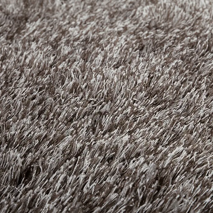 Kayoom Hochflorteppich Diamond - Champagner, Durchmesser: 160 cm, 100 % Polyester - Nahaufnahme eines weichen, luxuriösen Teppichs mit langen Fasern, der Komfort und Wärme vermittelt. Perfekt für ein gemütliches Ambiente.