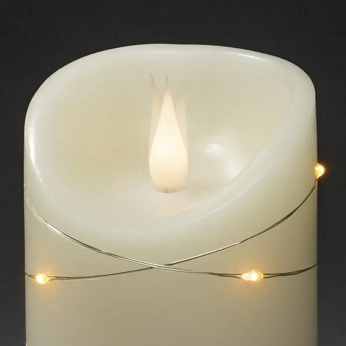 Konstsmide LED-Echtwachskerze - Ø x H: 7,5 x 13,5 cm, Creme - Nahaufnahme einer LED-Kerze mit warmweißen Lichtern, die um den Körper gewickelt sind, ideal für stimmungsvolle Beleuchtung im Haus.