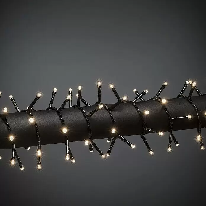 Konstsmide LED-Lichterkette - Außen, Lichtfarbe: Warmweiß, Anzahl Leuchtmittel: 400 Stk., Netzbetrieben - Leuchtende warmweiße LED-Lichterkette mit schwarzem Kabel, um einen dunklen Zylinder gewickelt.