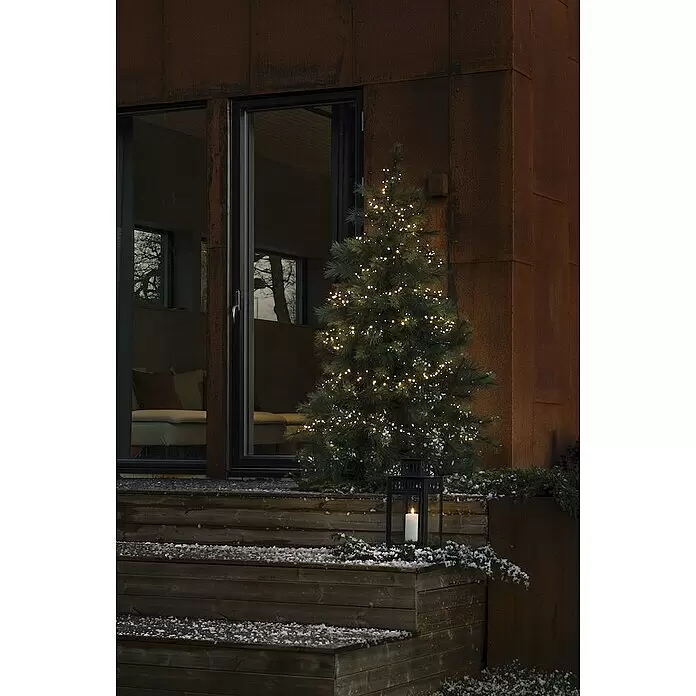 Konstsmide LED-Lichterkette - Außen, Lichtfarbe: Warmweiß, Anzahl Leuchtmittel: 400 Stk., Netzbetrieben - Ein beleuchteter Weihnachtsbaum und eine Laterne schmücken verschneite Holzstufen und schaffen eine warme, einladende Winteratmosphäre.