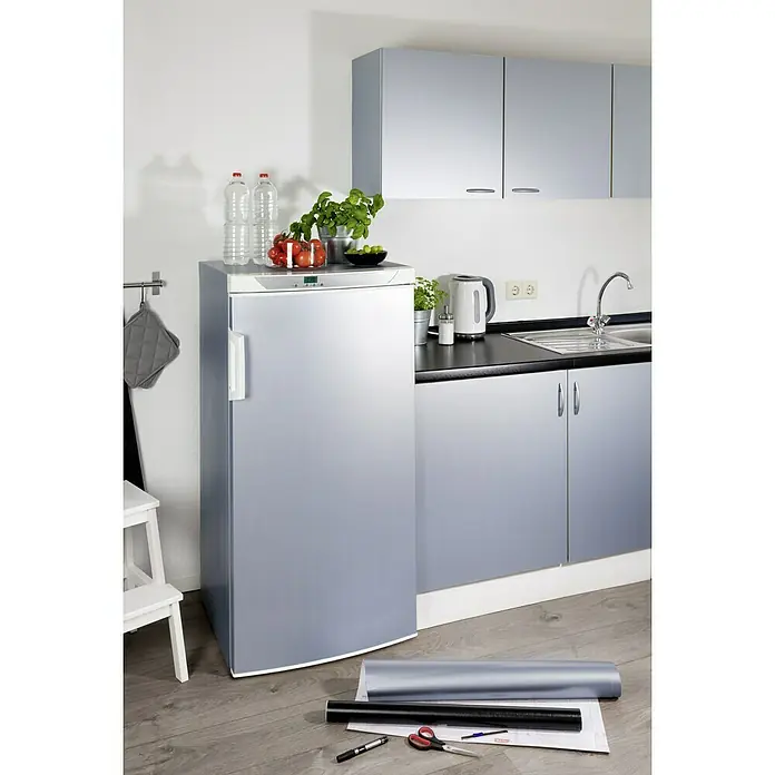 D-c-fix Metalleffektfolie Metallic - 150 x 67,5 cm, Silber, Selbstklebend - Silberner Kühlschrank mit silbernen Folienrolle auf dem Boden in einer modernen Küche.