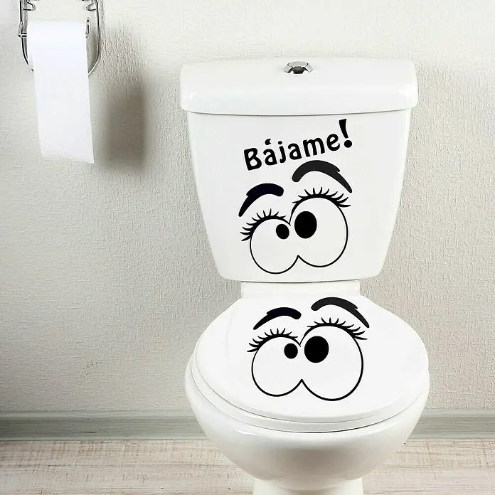 Vinilo de pared Bájame - 68 x 48 cm, Gris viejo, Plástico - Un inodoro blanco con adhesivos de ojos divertidos y el texto "Bájame!", que añade un toque humorístico al baño.