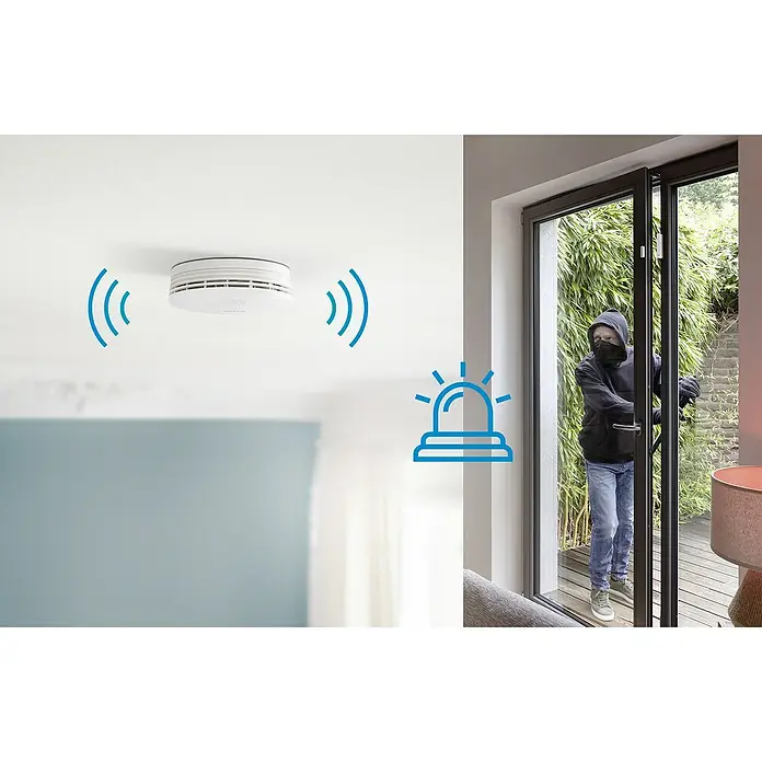 Bosch Smart Home Rauchwarnmelder II - Alarmsignal: 85 dB - Ein intelligenter Rauchmelder an der Decke überwacht ein Haus vor Eindringlingen, die durch eine Tür eindringen wollen.