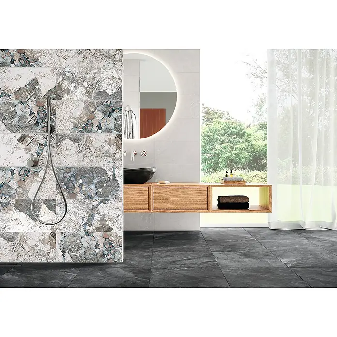 Domicil Feinsteinzeugfliese Stone Art - 60 x 60 cm, Smoke Anthrazit, Matt - Elegantes Badezimmer mit marmorierten Fliesen, einem runden Spiegel und einem schwebenden Waschtisch aus Holz.