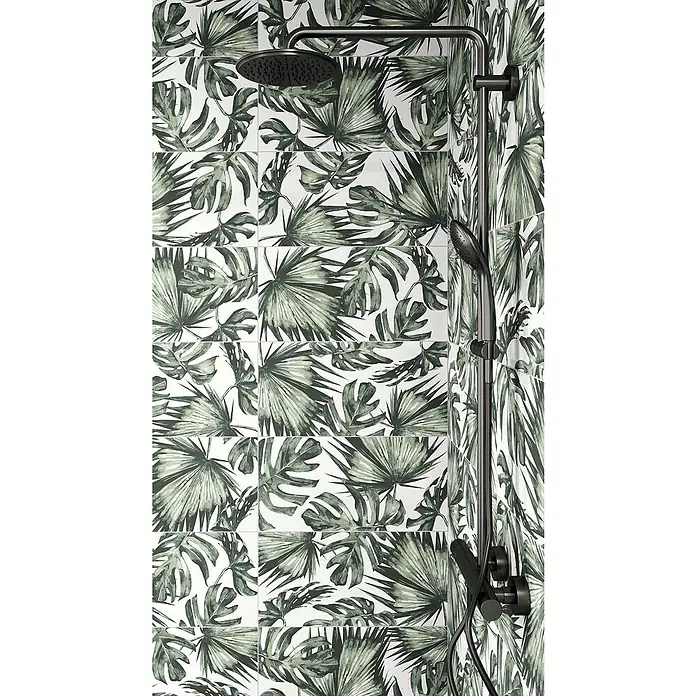 Domicil Wandfliese Living Concrete Jungledrum - 30 x 60 cm, Grün/Weiß, Matt - Nahaufnahme einer schwarzen Duschgarnitur mit Regendusche vor tropischen Blätterfliesen. Elegantes Design für ein modernes Badezimmer.