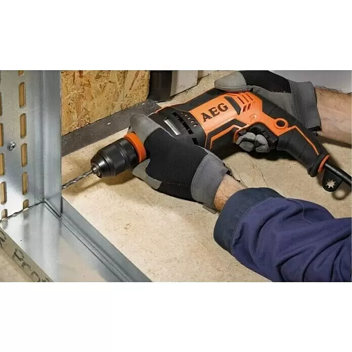 AEG Powertools Schlagbohrmaschine SBE 705 RE - 705 W, Schnellspannbohrfutter - Orange-schwarze AEG Bohrmaschine, von einer behandschuhten Hand gehalten, bohrt in ein Metallprofil.