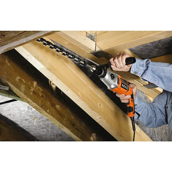 AEG Powertools Schlagbohrmaschine SB2E 1100 RV - 1.100 W, Schnellspannbohrfutter - Eine AEG-Bohrmaschine bohrt durch Holz mit einem langen Bohrer. Die Maschine ist orange und silberfarben.