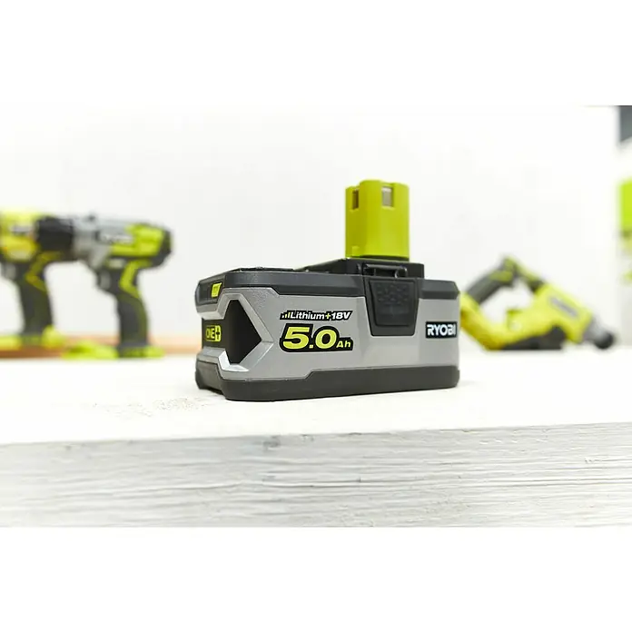 Ryobi ONE+ Akku - 18 V, 5 Ah, 2 Akkus - Ryobi 5.0Ah Lithium+ 18V Akku, ideal für verschiedene Elektrowerkzeuge, auf einer Werkbank. Im Hintergrund Werkzeuge.