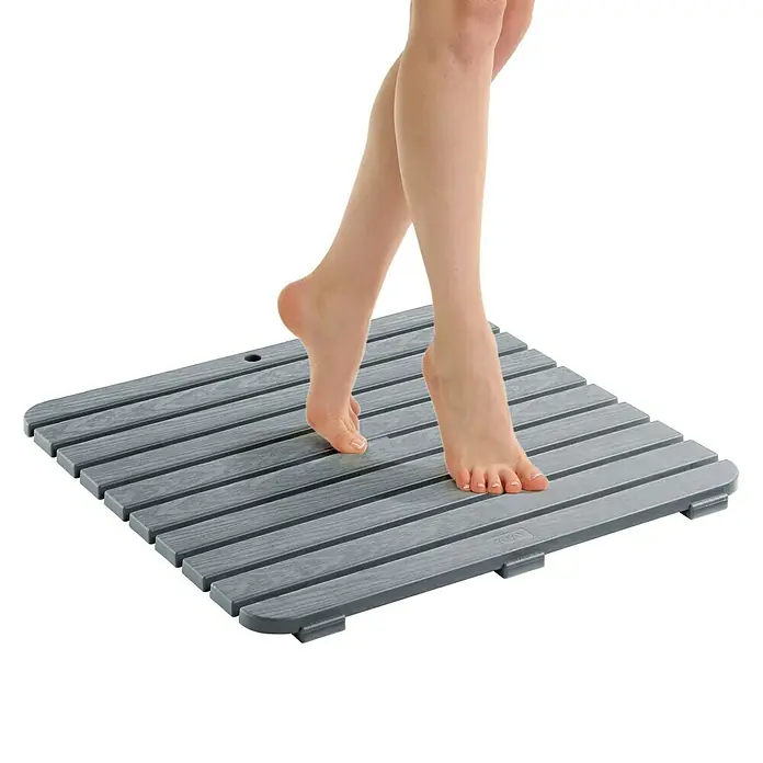 Tatay Tarima de baño - L x An: 55 x 55 cm, Gris, Polipropileno - Alfombra de baño de madera gris con los pies de una persona sobre ella. La alfombra está hecha de listones de madera y es antideslizante.