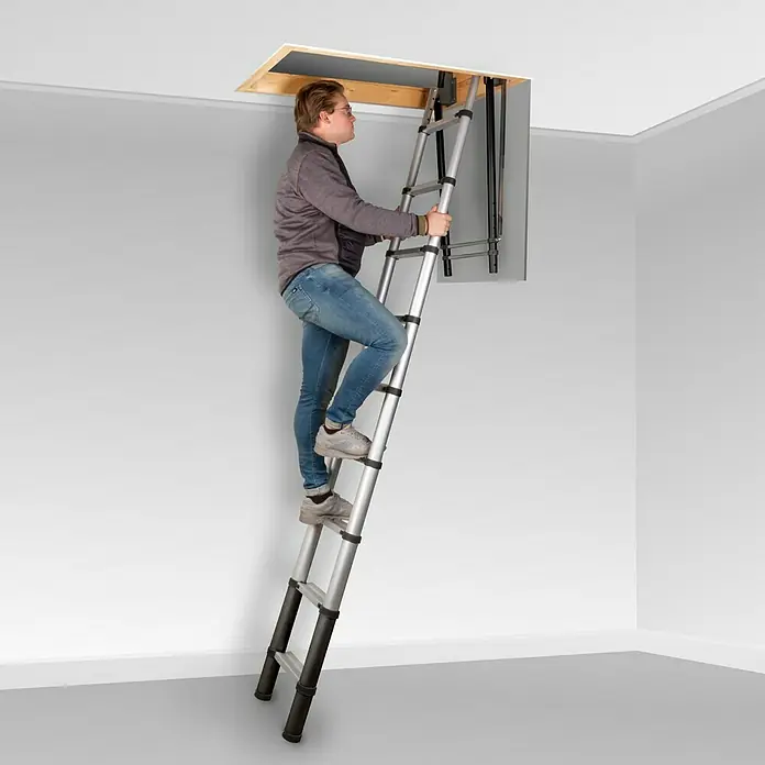 Batavia Teleskopleiter Giraffe - Breite Deckenöffnung: 60 cm, Länge Deckenöffnung: 90,5 cm - Ein Mann steigt eine ausziehbare Dachbodentreppe hoch, die sich durch ihr silbernes Teleskopdesign auszeichnet und einfachen Zugang zum Dachboden ermöglicht.