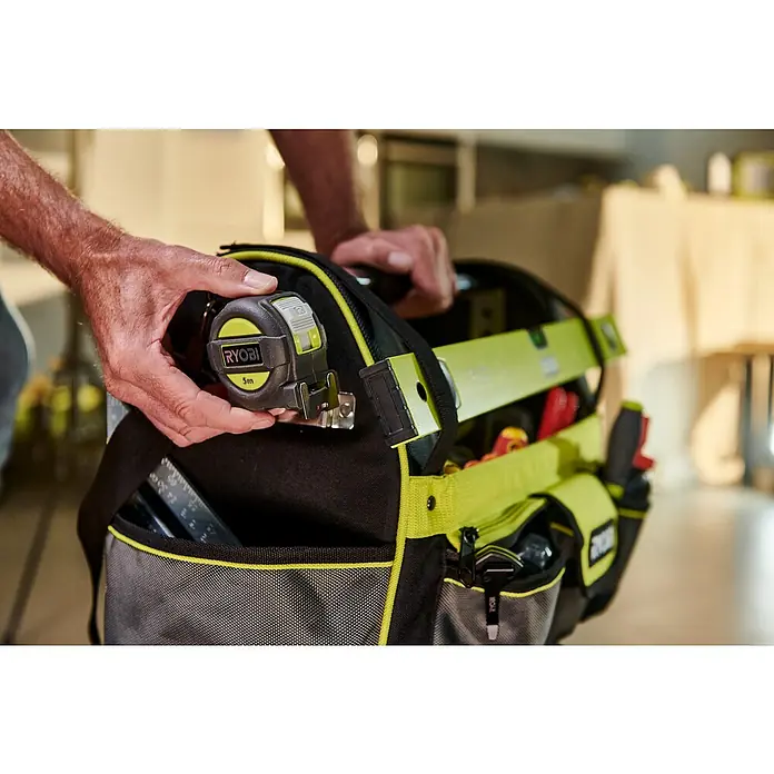 Ryobi Werkzeugtasche RSSLOT1 L - Größe: L, Polyester - Ein Nahaufnahme zeigt eine Ryobi 5m Messbandrolle, die an einer Ryobi Werkzeugtasche befestigt ist, mit viel Platz für andere Werkzeuge.