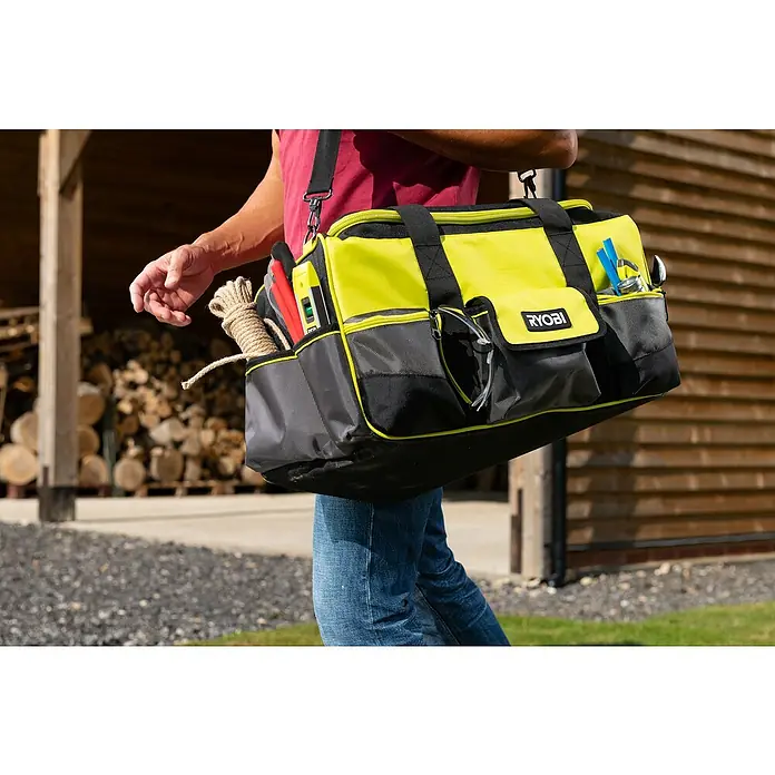 Ryobi Werkzeugtasche RSSLTB1 L - Polyester, Größe: L - Nahaufnahme einer RYOBI-Werkzeugtasche in Gelb und Schwarz, getragen von einer Person mit Werkzeugen in den Seitentaschen.