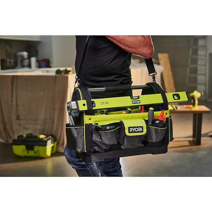 Ryobi Werkzeugtasche RSSLOT1 L - Größe: L, Polyester - Nahaufnahme einer Ryobi Werkzeugtasche mit Werkzeugen, die von einer Person getragen wird. Die Tasche ist schwarz, gelb und mit dem Ryobi Logo versehen.
