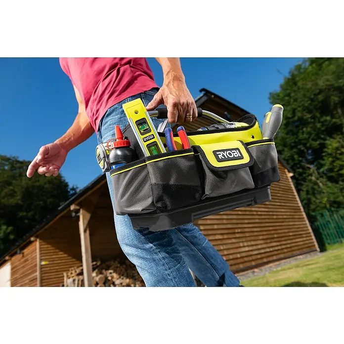 Ryobi Werkzeugtasche RSSSOT1 S - Größe: S, Polyester - Nahaufnahme einer Ryobi Werkzeugtasche, die von einer Person im Freien getragen wird, mit Werkzeugen wie einer Wasserwaage und Schraubendrehern.