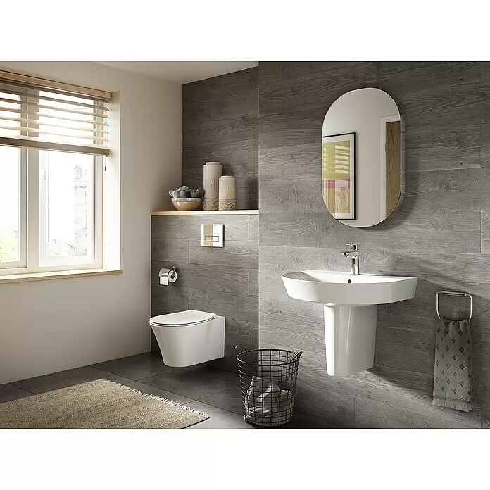 Ideal Standard Connect Air Wand-WC-Set AquaBlade - Spülrandlos, Ohne Spezialglasur, Spülform: Tief, WC Abgang: Waagerecht, Weiß - Ein modernes Badezimmer mit wandhängender Toilette, weißem Säulenwaschbecken und grauen Holzoptik-Fliesen.