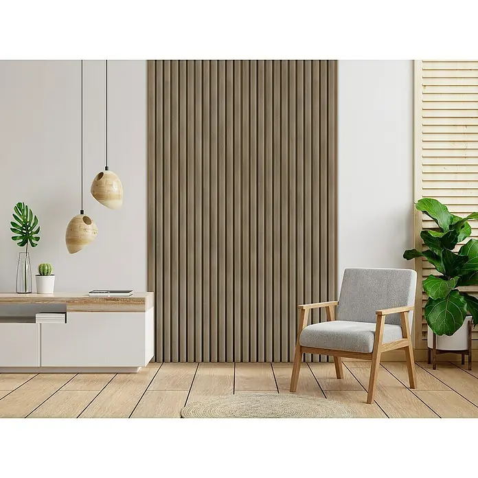 Dioco Revestimiento decorativo alistonado - L x An: 220 x 17 cm, Teka - Un interior elegante con una pared decorativa de listones de madera, una butaca gris claro y un aparador moderno que crean un espacio vital acogedor.