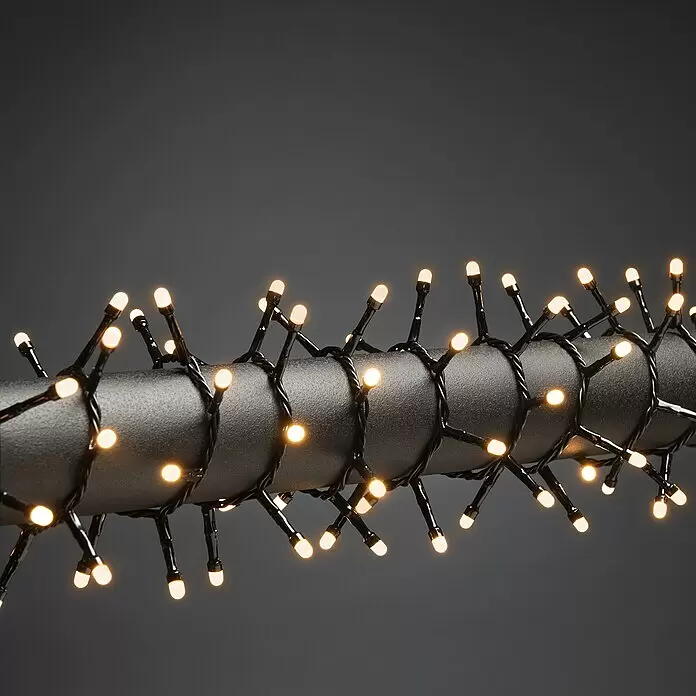Konstsmide LED-Lichterkette Gefrostet - Außen, Lichtfarbe: Bernstein, Anzahl Leuchtmittel: 600 Stk., Netzbetrieben - Warmweiße LED-Lichterkette mit schwarzen Kabeln um ein dunkles, strukturiertes Rohr gewickelt.