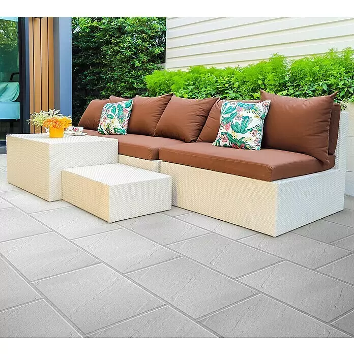 Terrassenplatte Wild Stone - 60 x 40 x 4 cm, Perla, Beton - Ein weißes Outdoor-Korbmöbelset mit braunen Kissen und passenden Couchtischen auf einer gefliesten Terrasse.