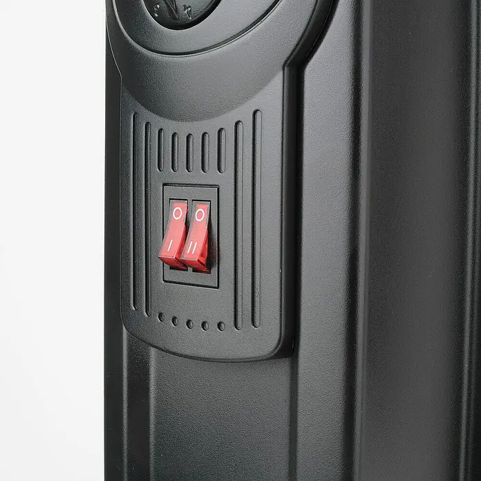 Black+Decker Ölradiator BXRA2300E - 2.300 W, Raumgröße bis ca. 23 m², Schwarz - Detailaufnahme eines schwarzen Heizkörpers mit zwei roten Schaltern. Praktisches Design für effiziente Wärmeregulierung im Haus.